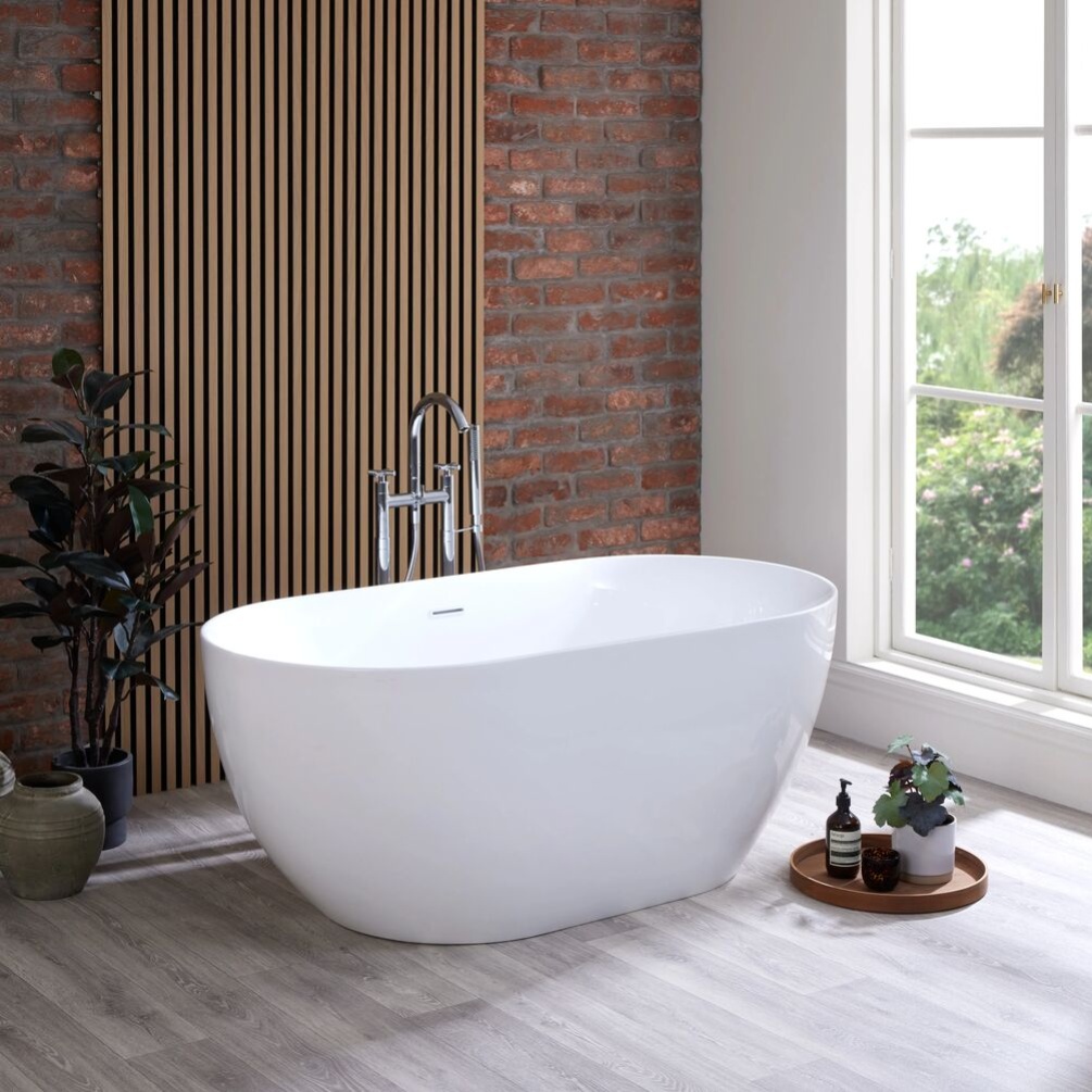 Product lifestyle image of Aussois 1500mm Gloss White Bath in front of window and brick wall with vertical grooved panellingSB216